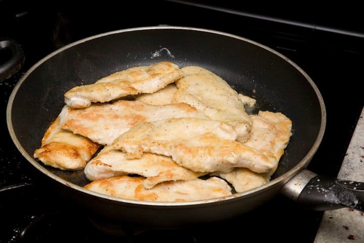 two shots of chicken breasts in a pan being seared for healthy chicken piccata