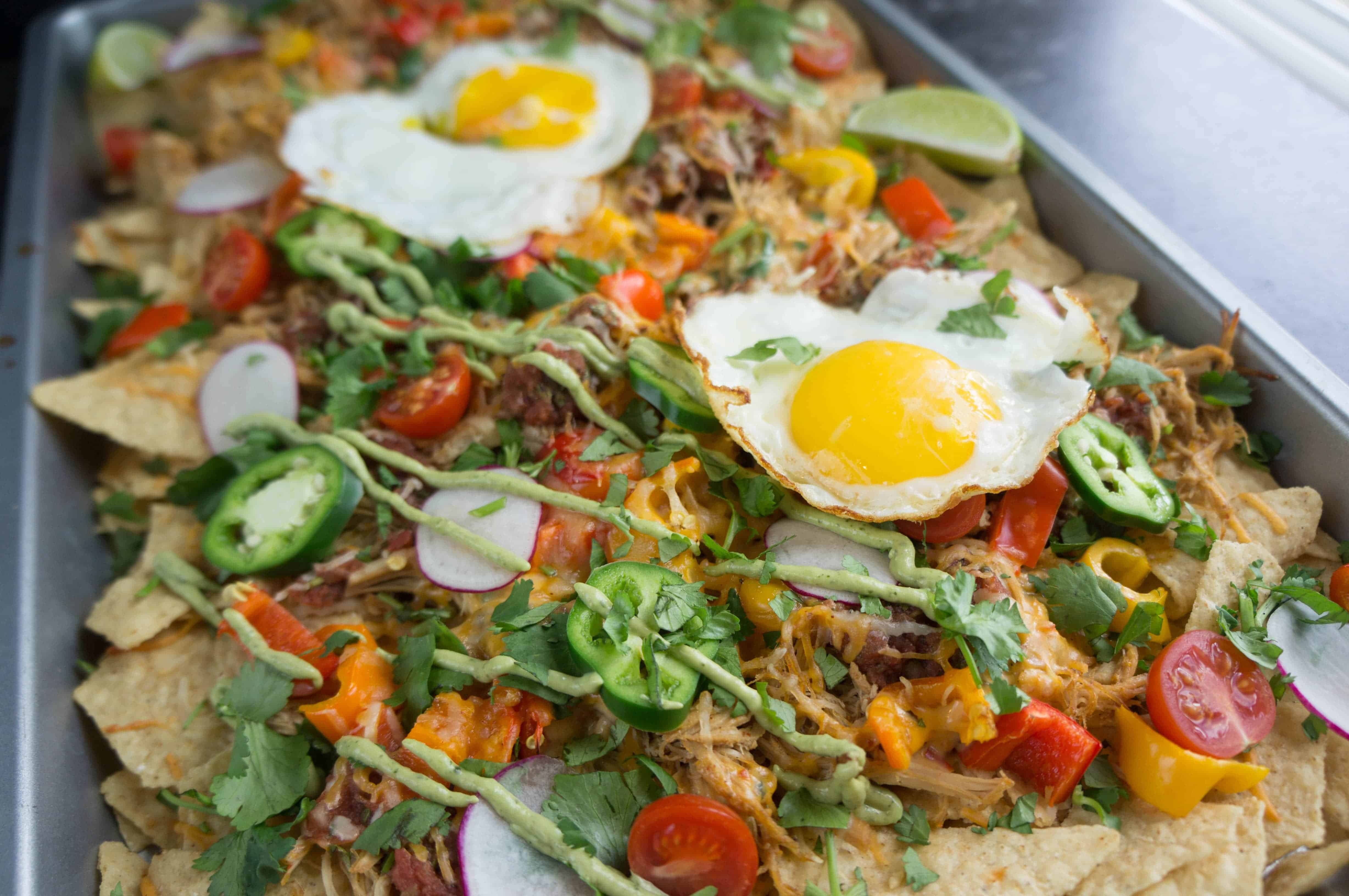 Game day snacks aren't complete without a big sheet pan of crispy cheesy goodness! Complete your tailgate menu with these pulled pork nachos.