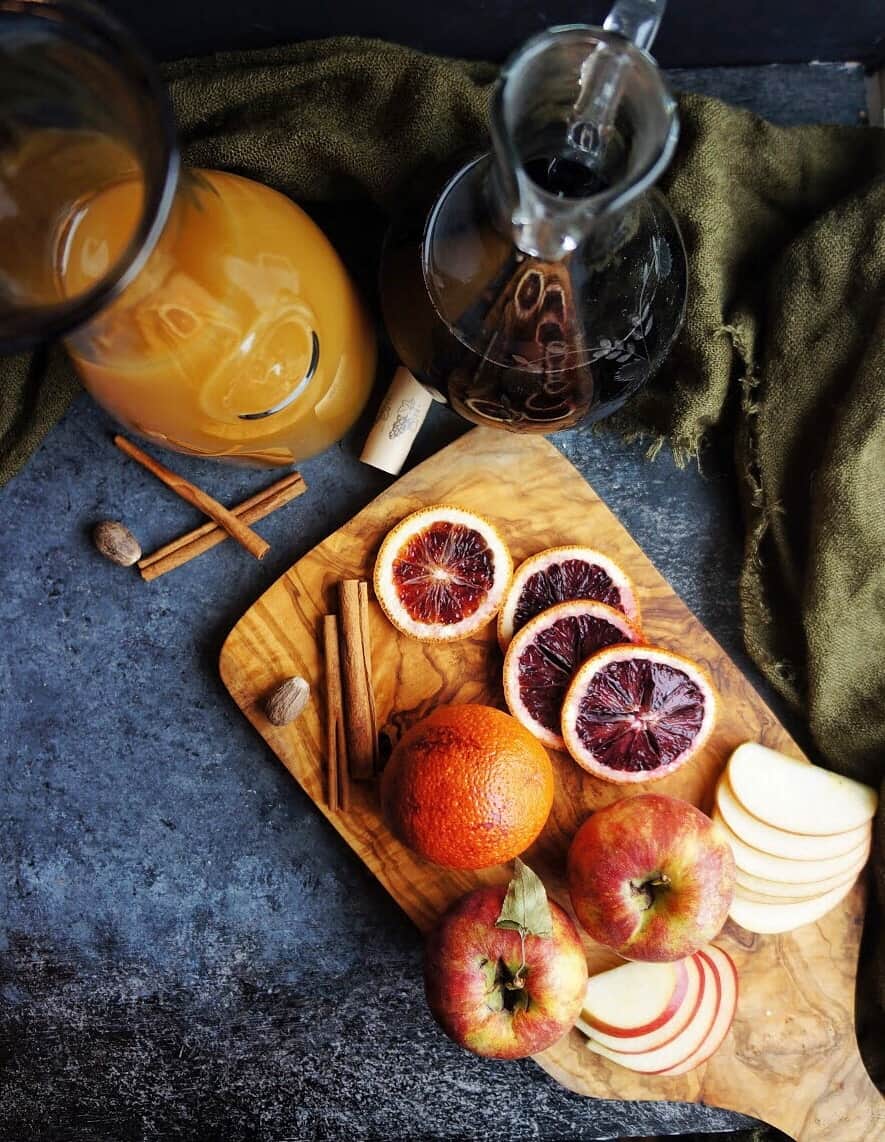 Fall red sangria Blood orange slices and sliced apples on a cutting board