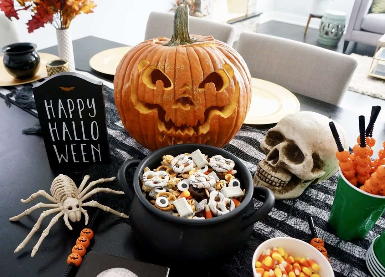 Halloween Trail Mix | Delicious blend of salty and sweet, this recipe for Halloween Trail Mix is perfect for a Fall snack or Halloween party! halloween trail mix on table with carved pumpkin