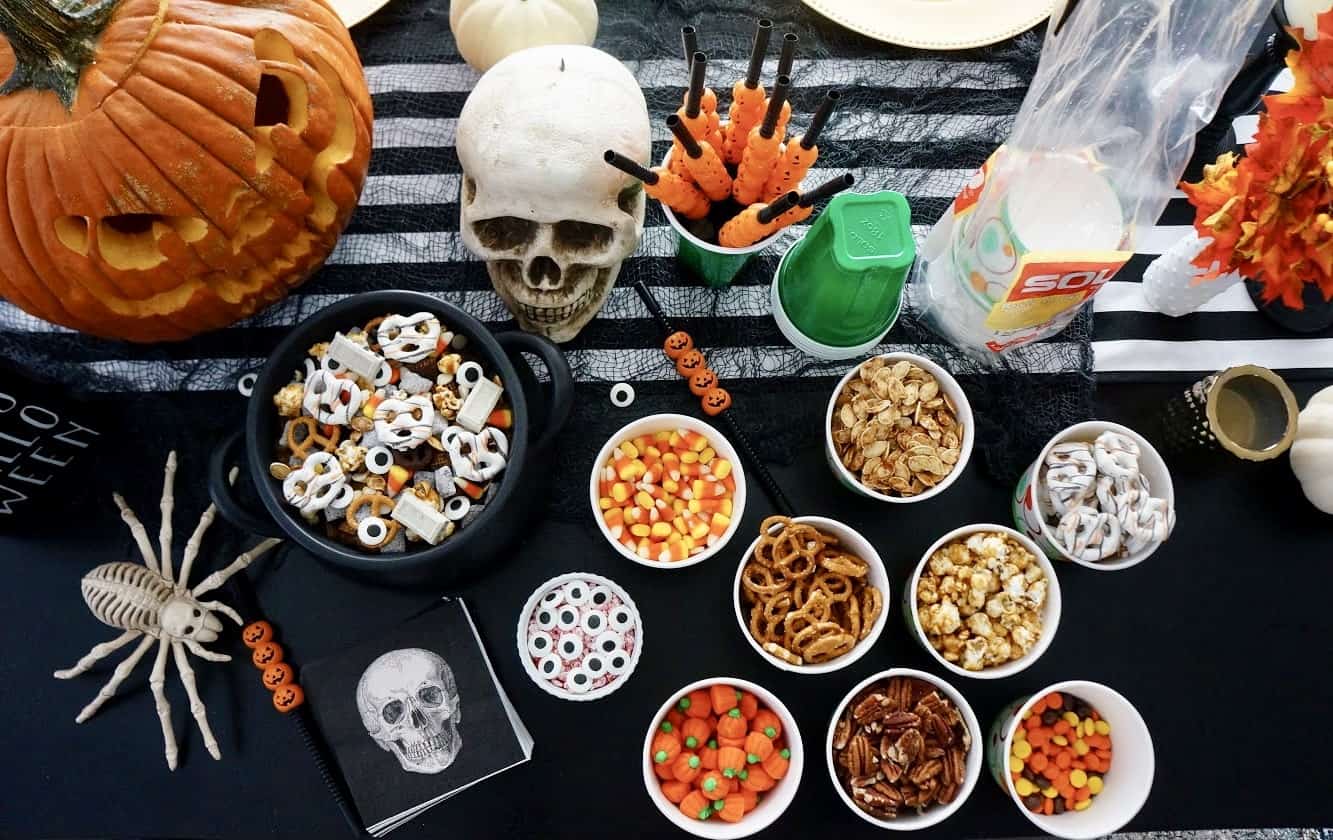 Halloween Trail Mix | Delicious blend of salty and sweet, this recipe for Halloween Trail Mix is perfect for a Fall snack or Halloween party! trail mix ingredients on Halloween table