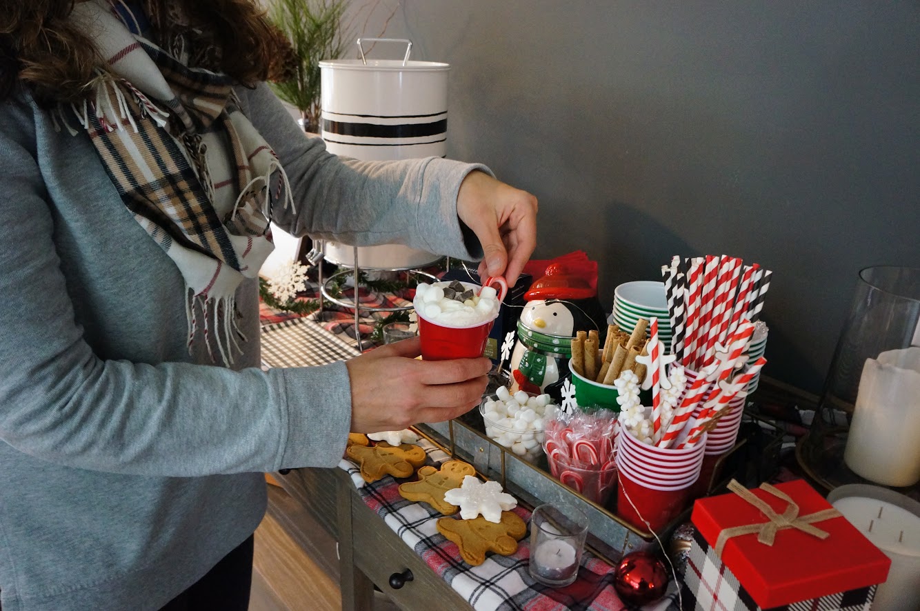 hot cocoa bar adding candy cane to hot cocoa