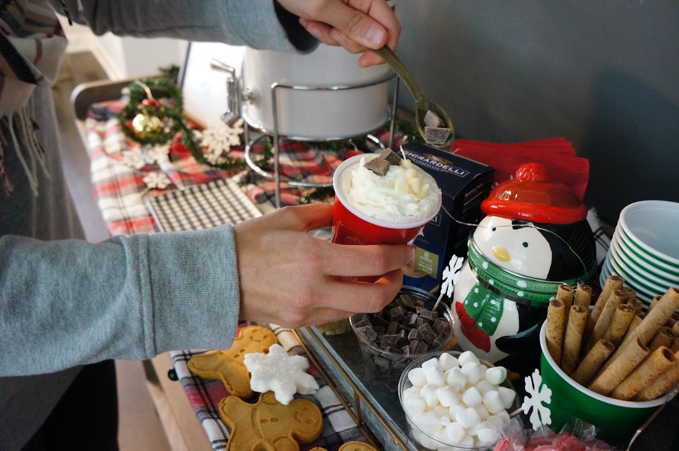 hot cocoa bar someone topping their hot cocoa at the hot cocoa bar