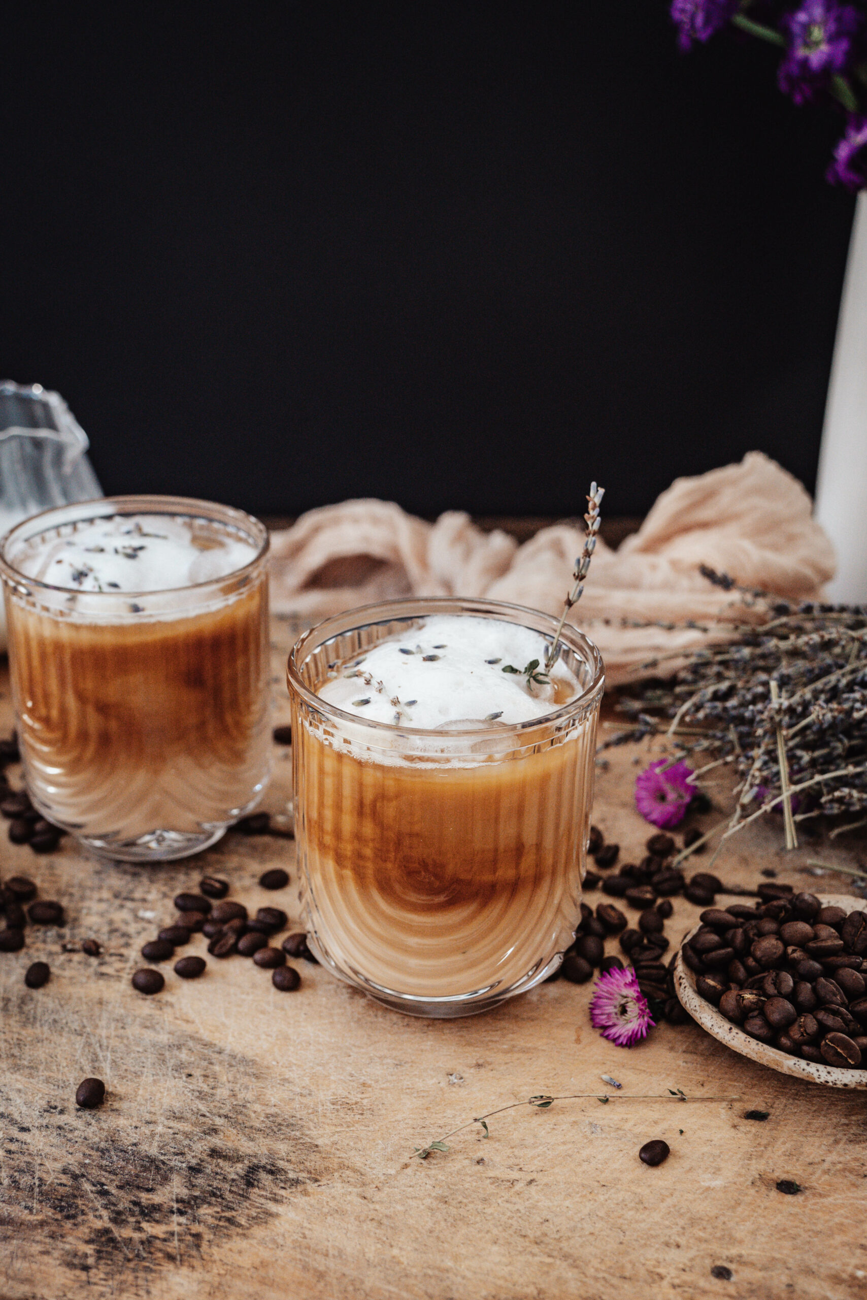 Iced Lavender Cold Brew Latte iced lavender latte in glass mug with dried lavender sprig garnish