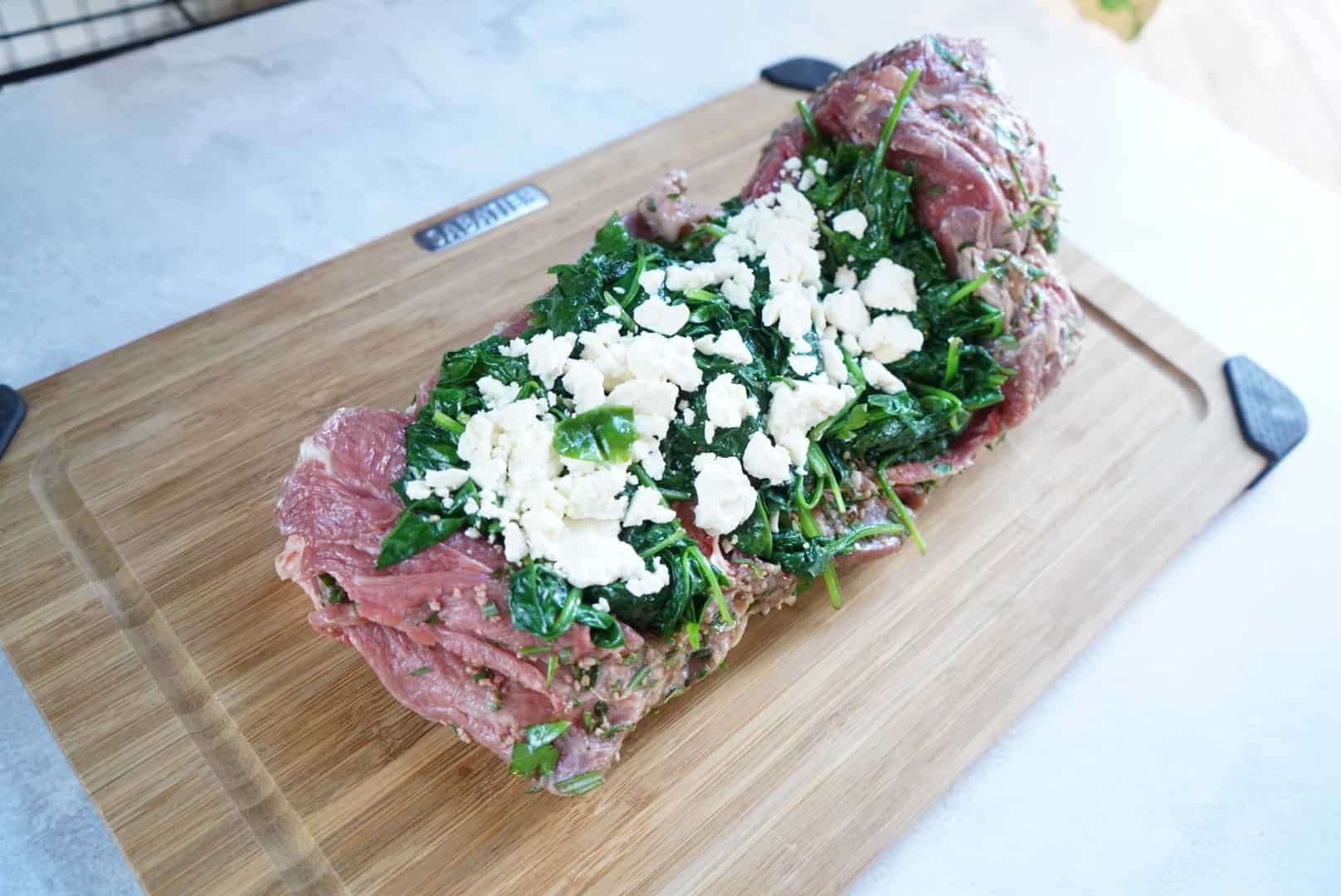stuffed leg of lamb raw leg of lamb with spinach and feta stuffing before rolling
