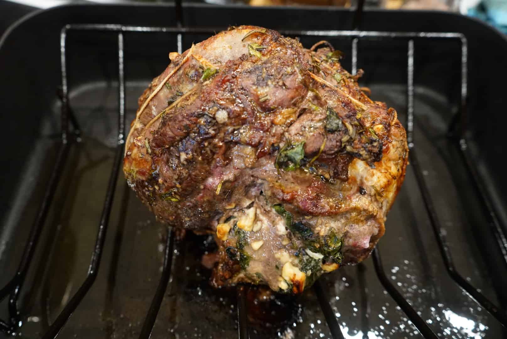 stuffed leg of lamb roasted stuffed leg of lamb on roasting rack in roasting pan