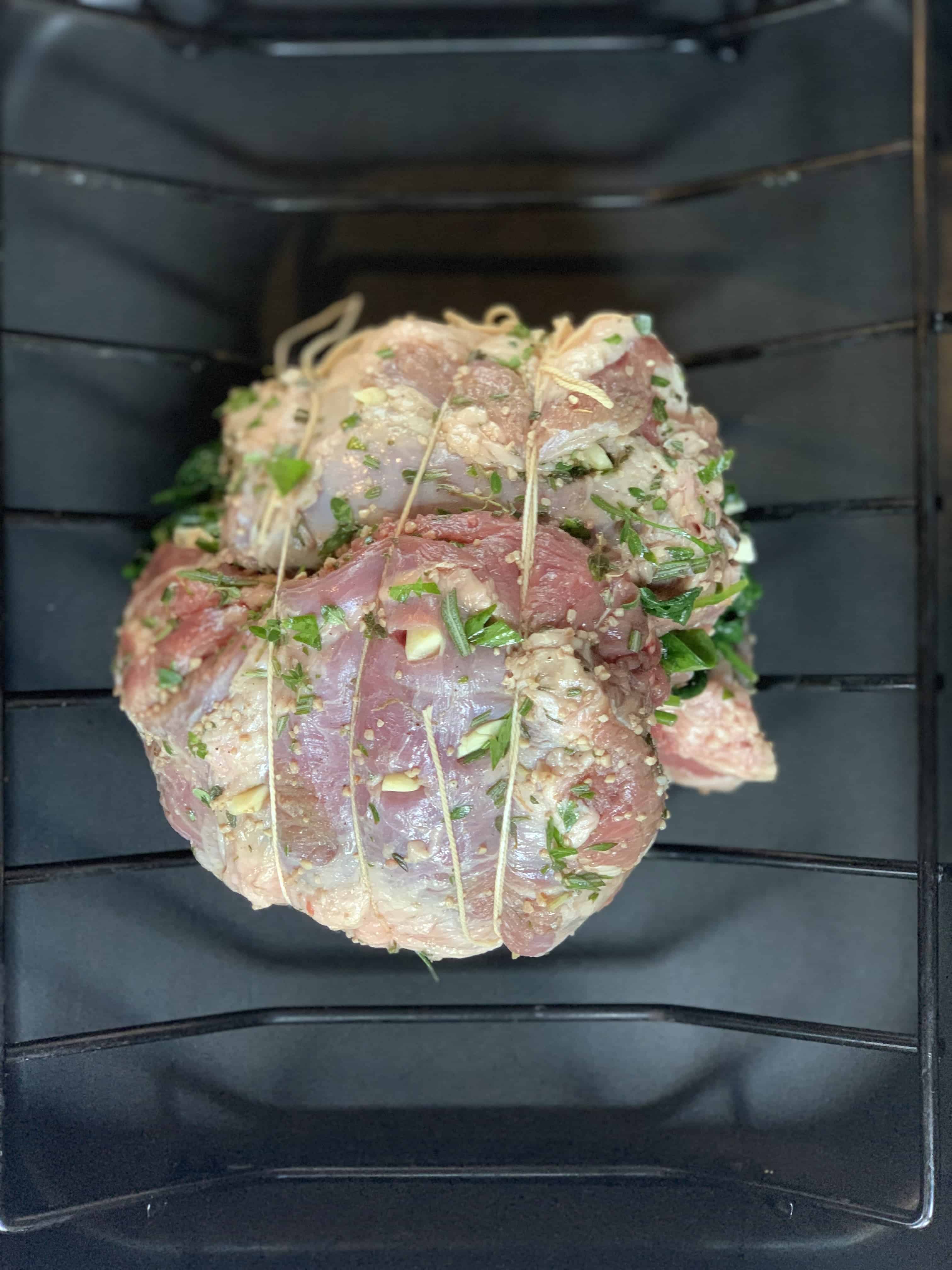 stuffed leg of lamb raw stuffed leg of lamb on roasting rack