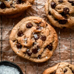 chocolate chip cookies on cooling rack and a small bowl of flaky salt