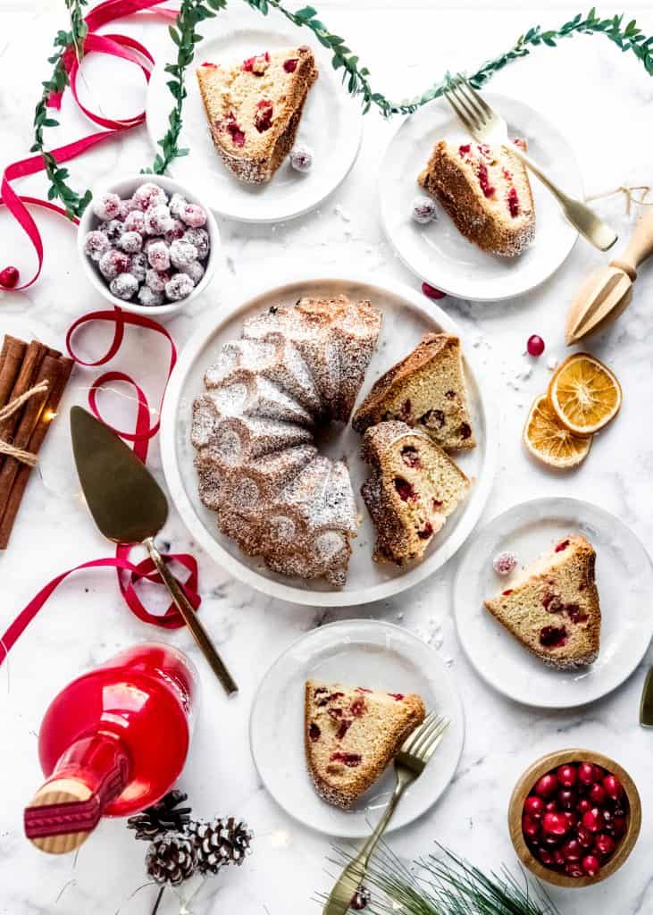 baked cranberry orange rum cake sliced on plates with festive holiday background