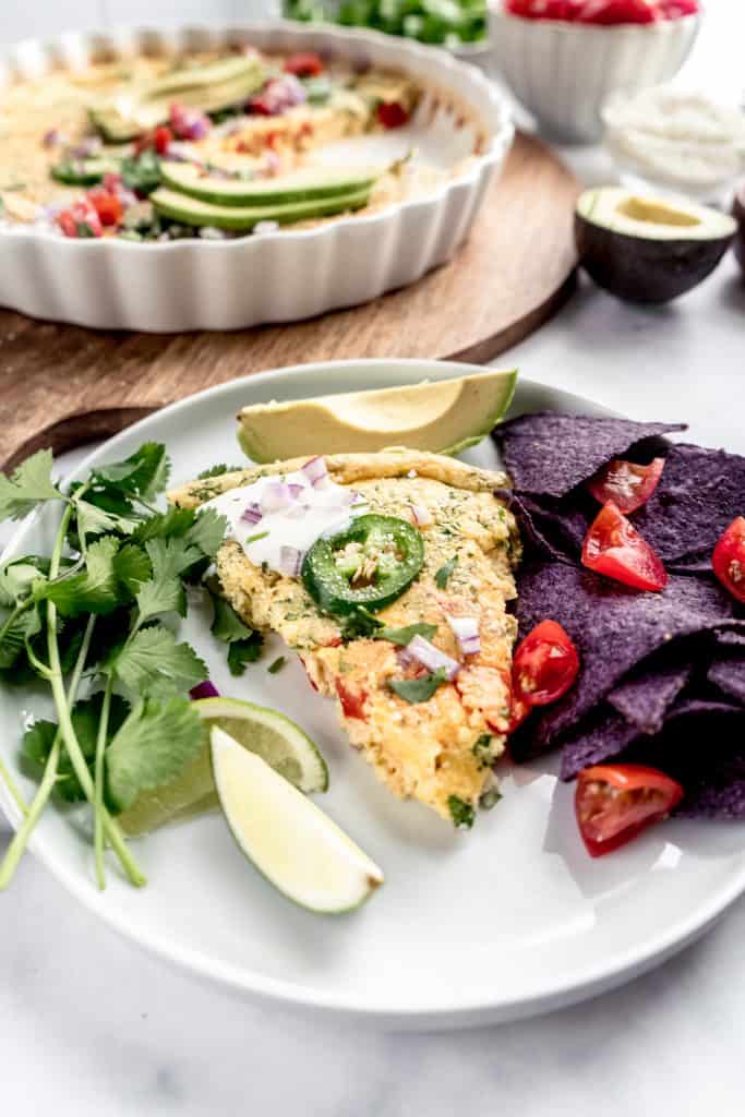 slice of taco frittata on plate with chips and salsa