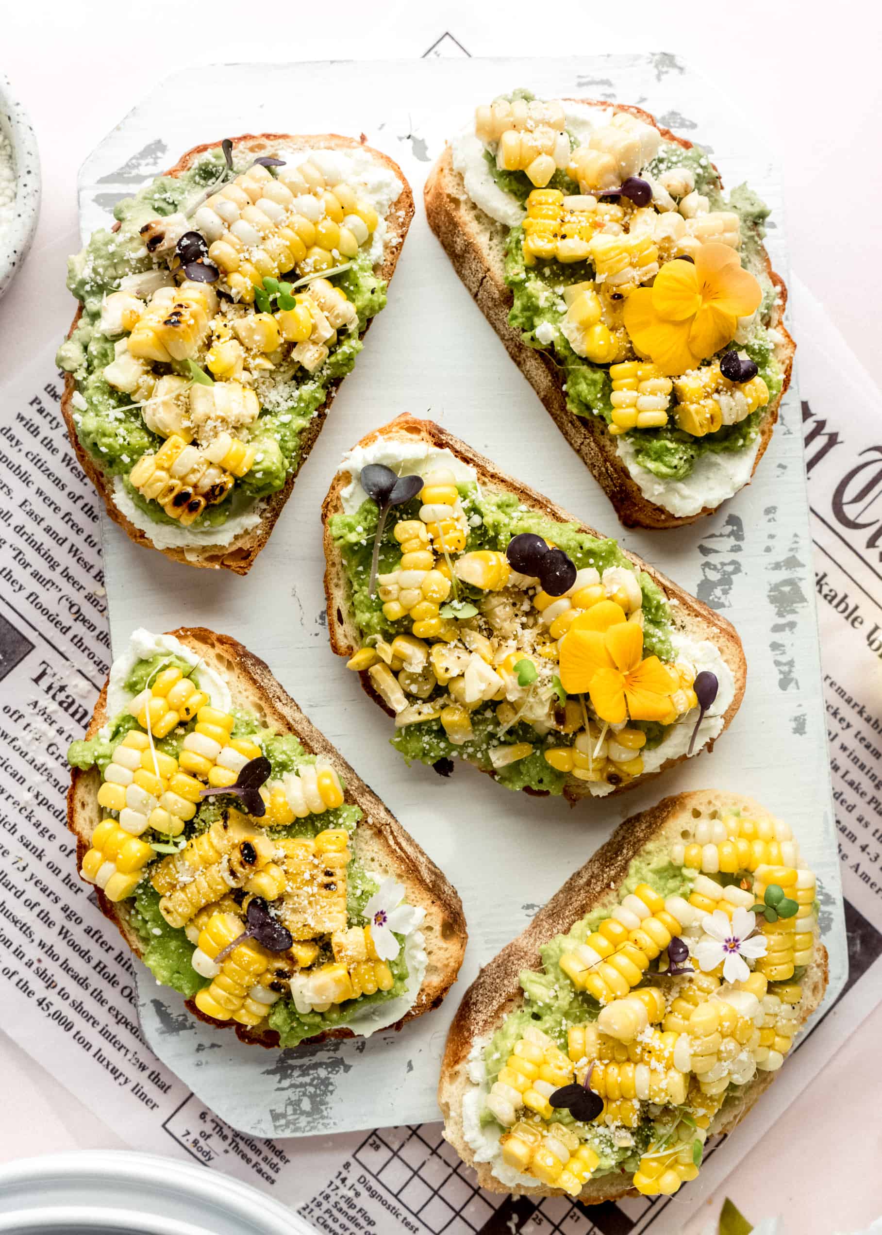sweet corn bruschetta slices on white cutting board
