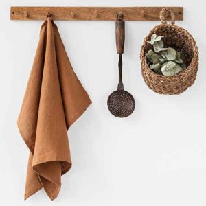 Orange linen towel and basket hanging on a coat rack