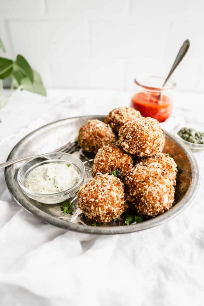 sweet corn arancini in metal dish with pesto aoili in sauce dish