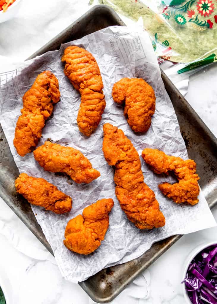 buffalo chicken fingers on baking sheet with parchment paper