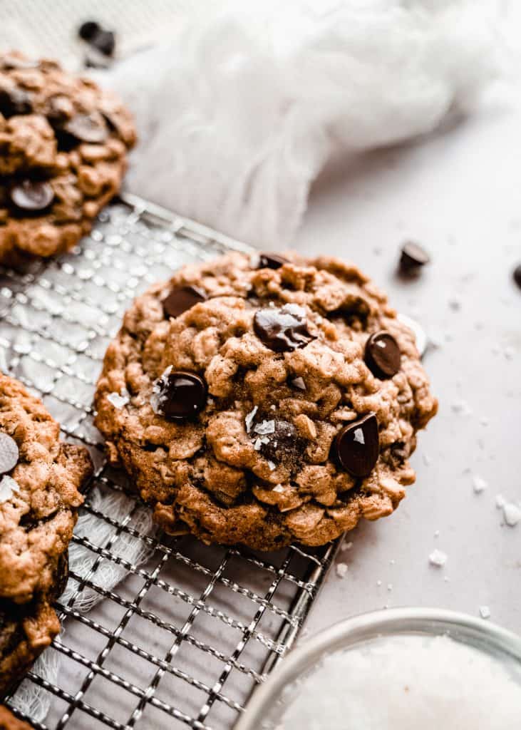 An up close 45 degree angle of Baked Chewy Oatmeal Chocolate Chip Cookies on a cooling rack