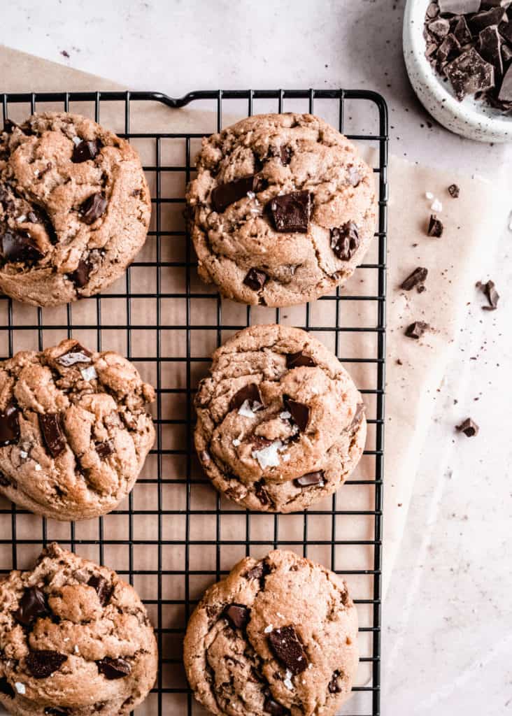 brown butter toffee chocolate chunk cookies baked on cooling rack, bowl of chopped chocolate on the side