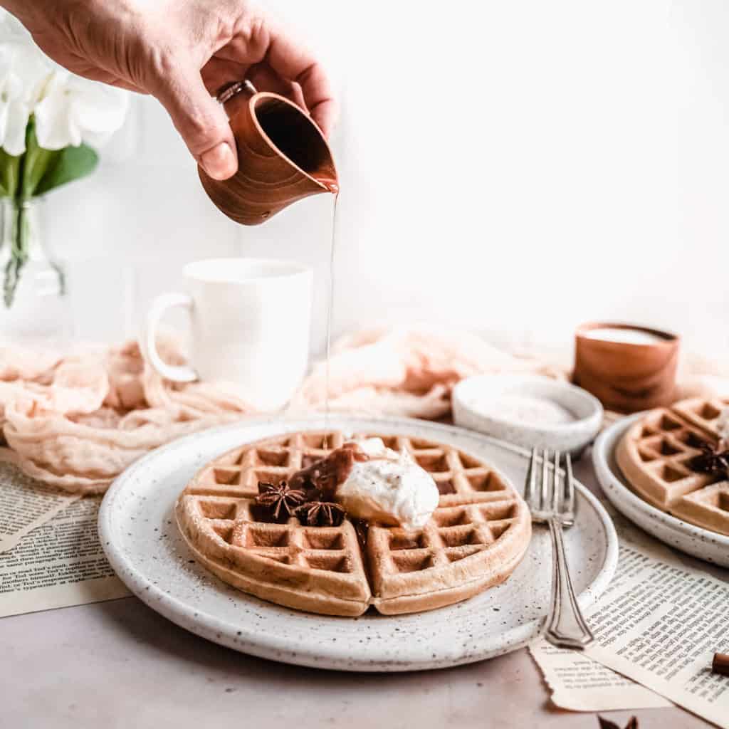 syrup being poured on apple butter waffles