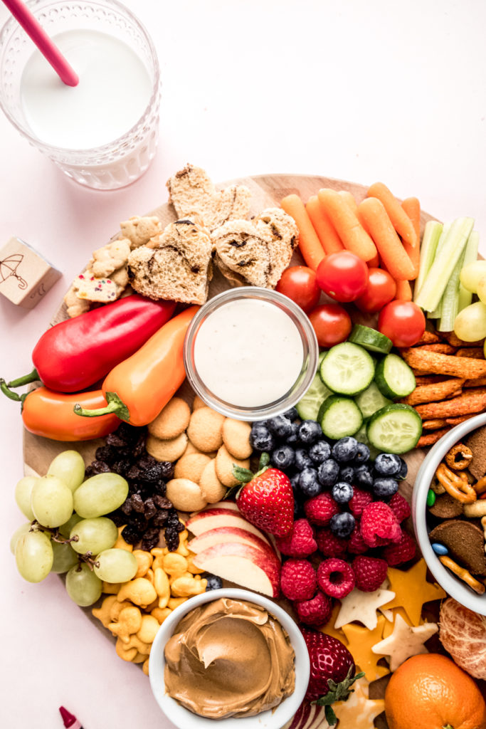 close up shot of peanut butter sandwiches, cookies and fruit on kids charcuterie board