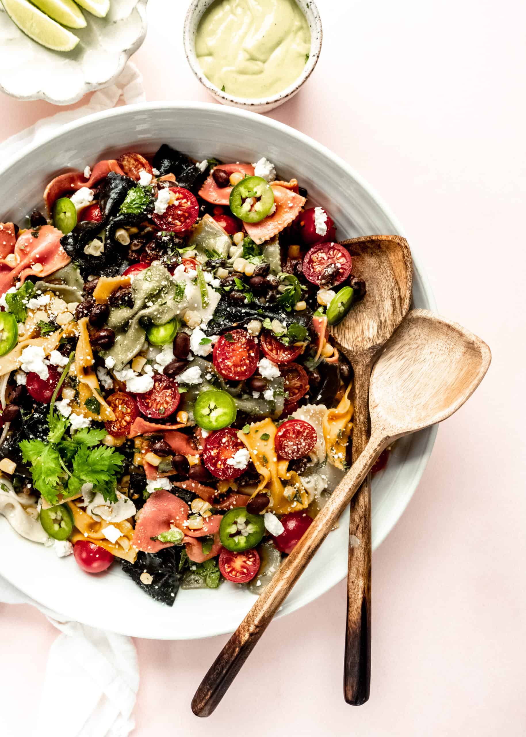 Mexican pasta salad in large bowl with wooden tongs