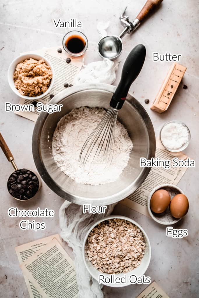 individual ingredients for Chewy Oatmeal Chocolate Chip Cookies in bowls on marble backdrop