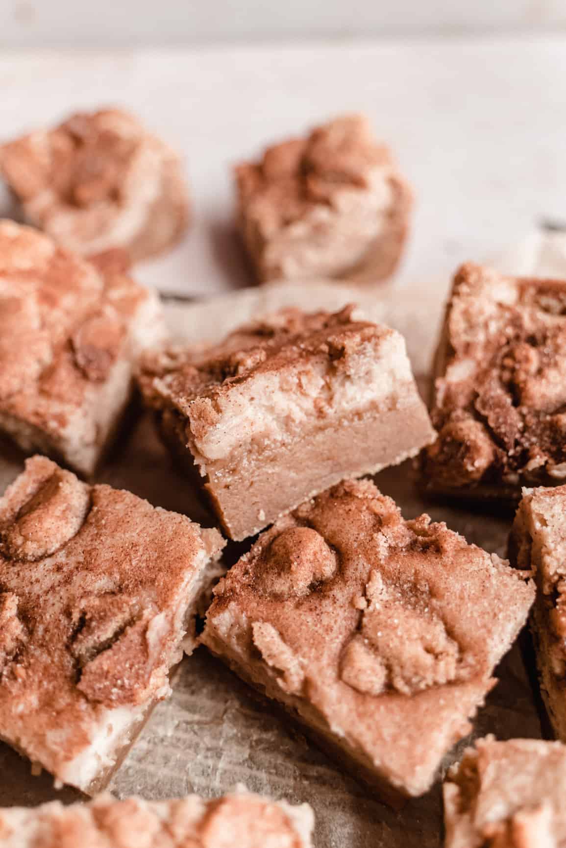 close up of snickerdoodle cheesecake bars cut into squares on cooling rack
