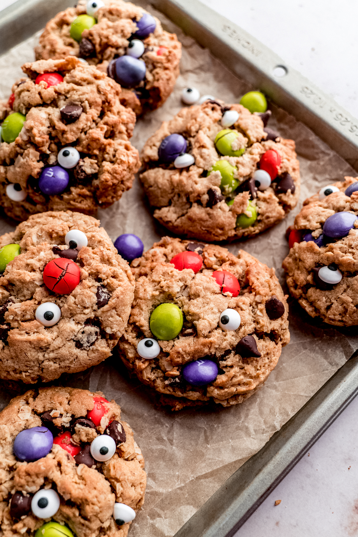 Close up side shot of Halloween Monster cookies on sheet pan with parchment paper