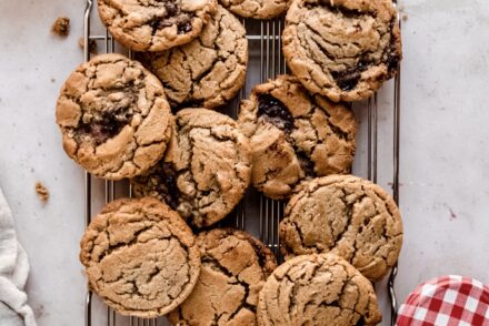 peanut butter and jelly cookies on wire cooling rack , peanut butter in small bowl next to the rack
