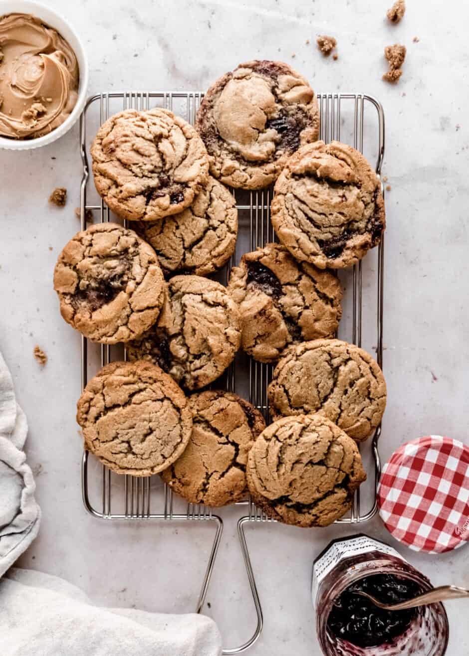 peanut butter and jelly cookies on wire cooling rack , peanut butter in small bowl next to the rack