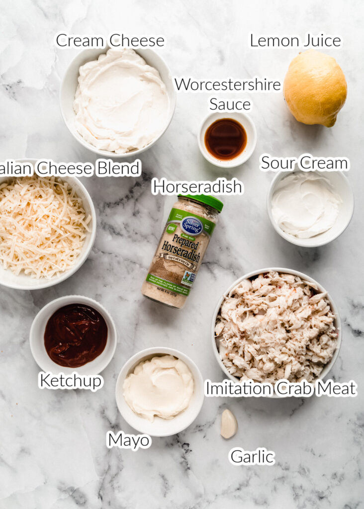 ingredients for imitation crab dip in individual bowl on a marble background 