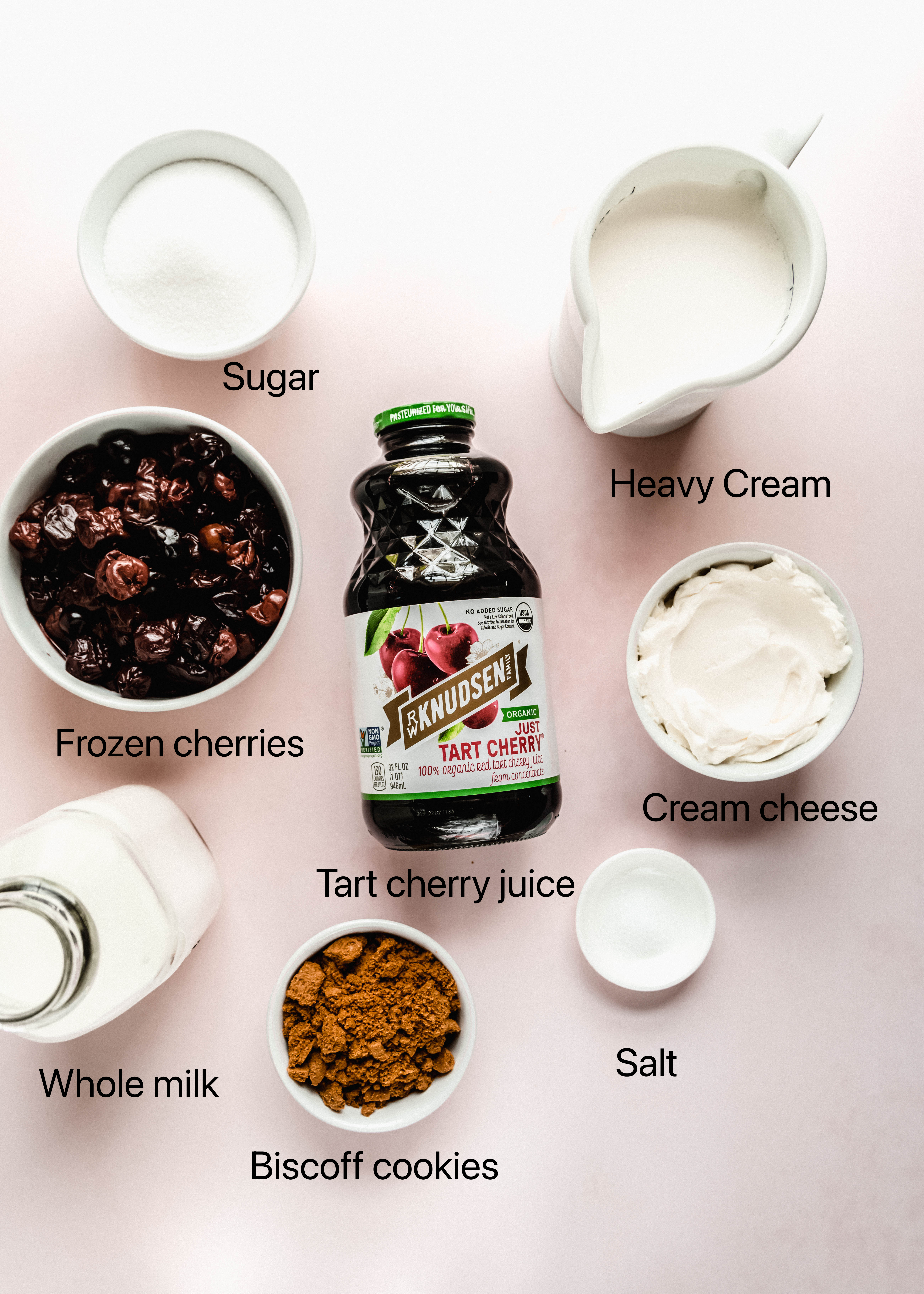 cherry cheesecake ice cream ingredients in small white bowls on pink background