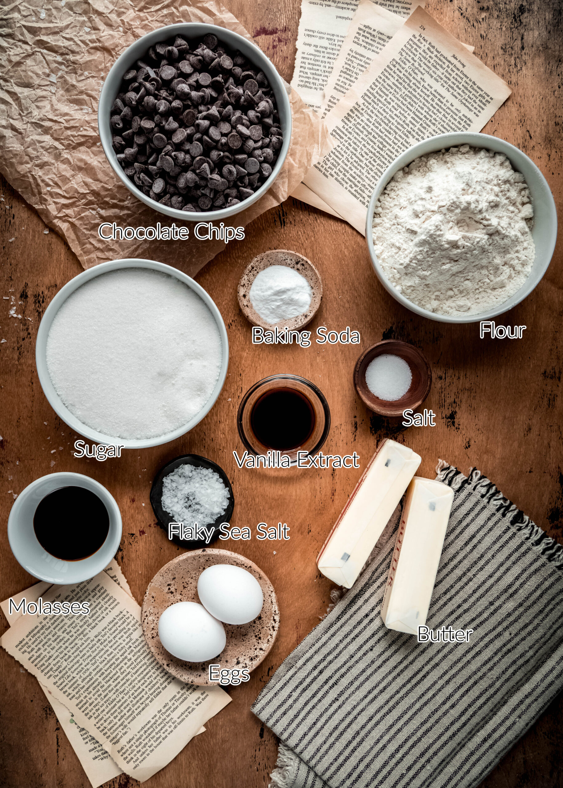 overhead shot of ingredients for chocolate chip cookies in individual bowls on wood background