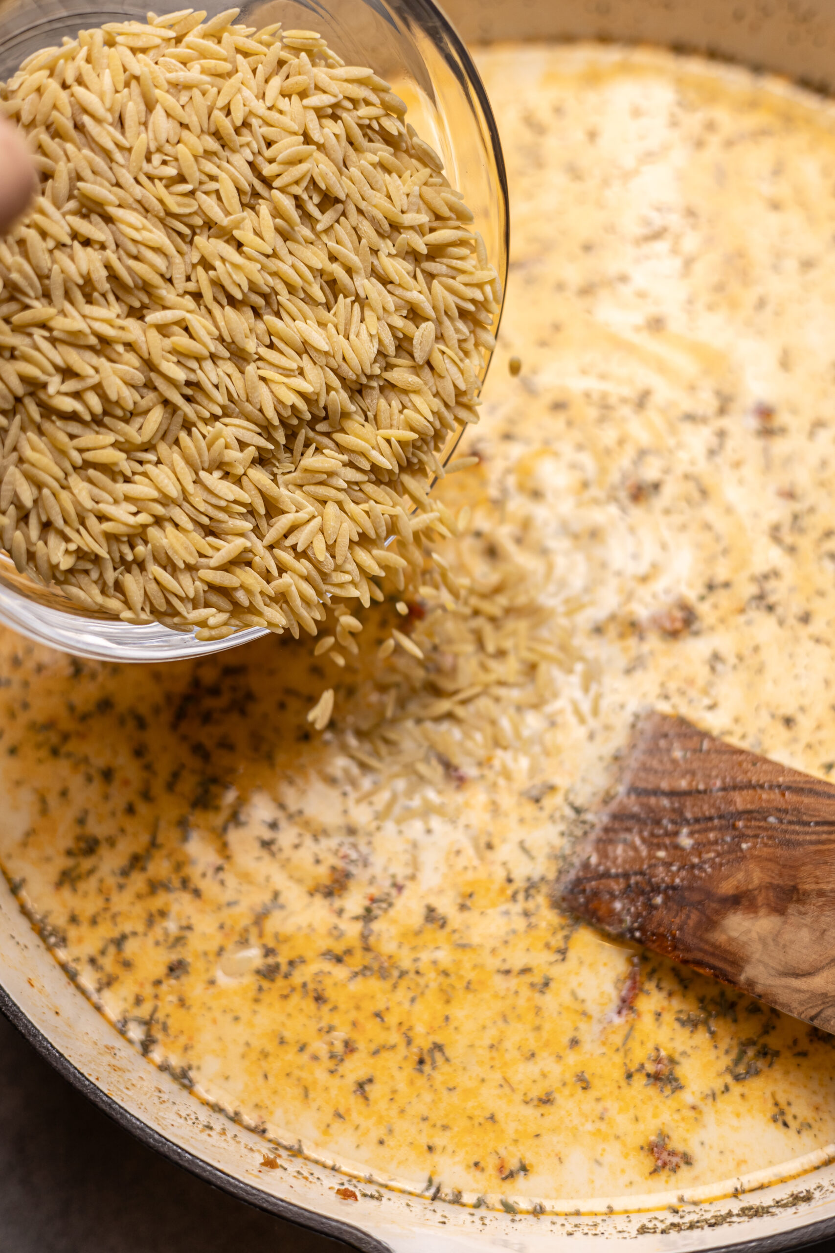 orzo being poured into skillet for marry me chicken orzo