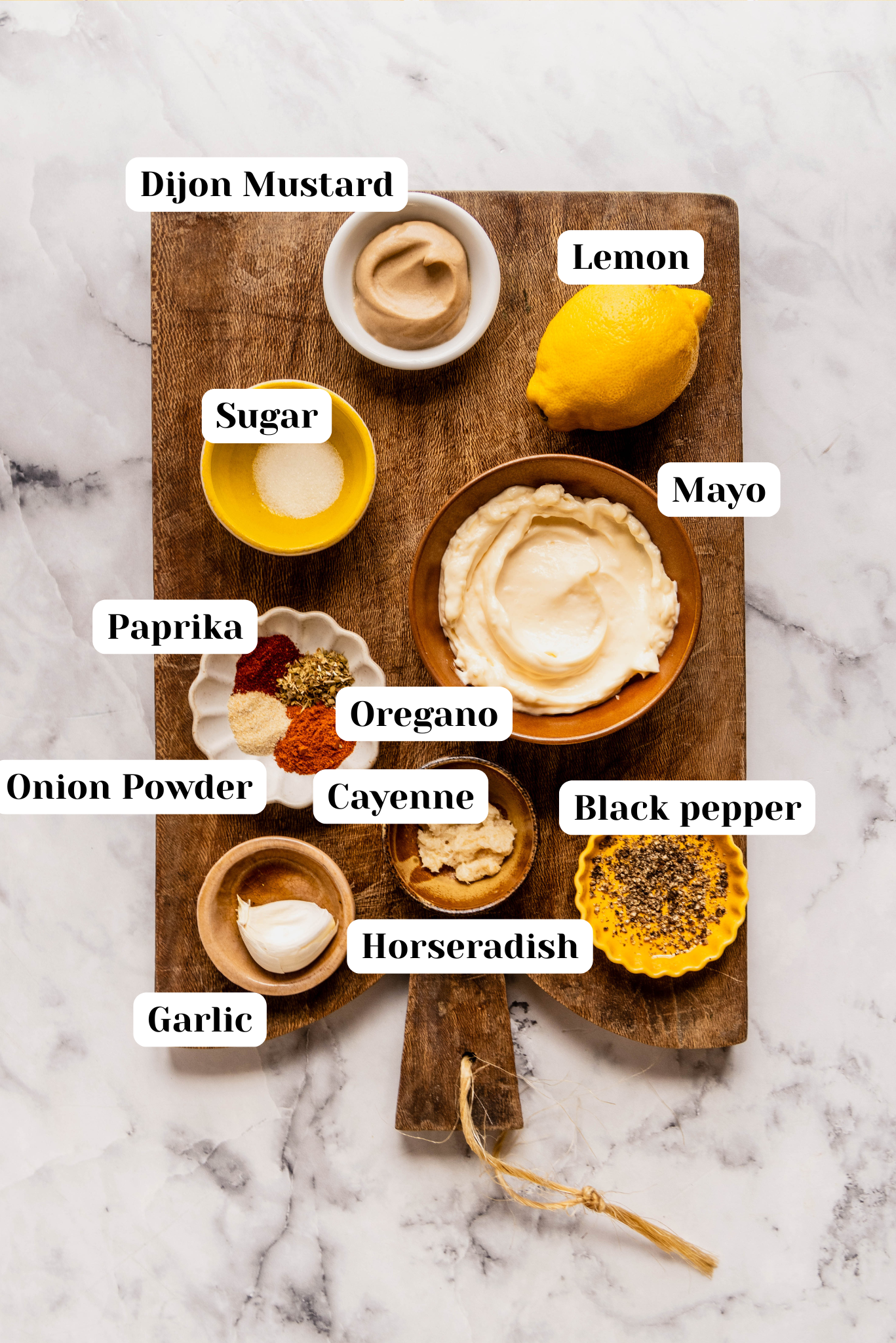 Overhead view of labeled ingredients for homemade Remoulade Sauce on a wooden cutting board, including mayonnaise, Dijon mustard, lemon, garlic, horseradish, sugar, paprika, oregano, cayenne, onion powder, and black pepper on a white marble background.
Select 58 more words to run Humanizer.